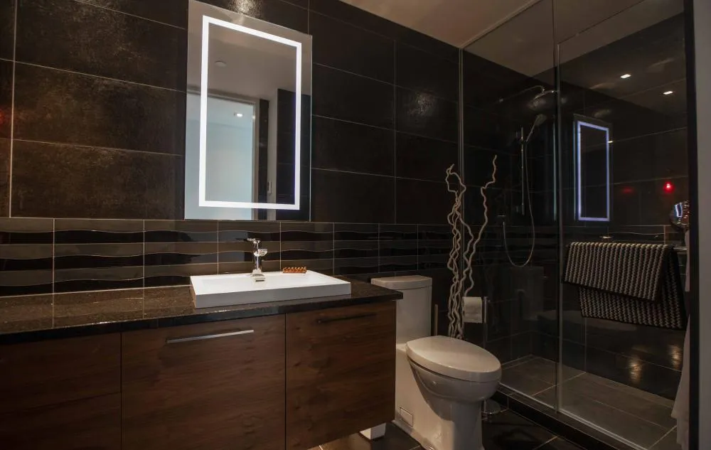 Salle de bain moderne avec douche vitrée et miroir LED